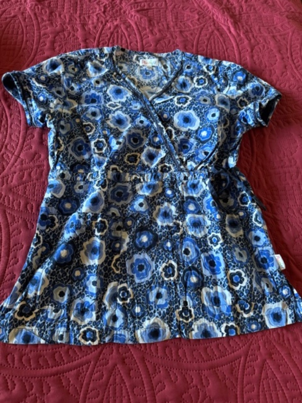 Blue/white/black/floral scrub top / pockets in front/tie back  Med.
